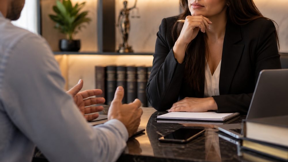 Advogada ouvindo o relato de um cliente em reunião no escritório
